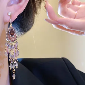 Detailaufnahme von eleganten Vintage-Ohrhängern mit glitzernden Strasssteinen und Quasten