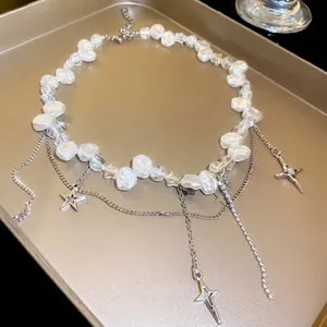 Fashionable baroque pearl necklace with zirconia star pendants on a warm golden tray