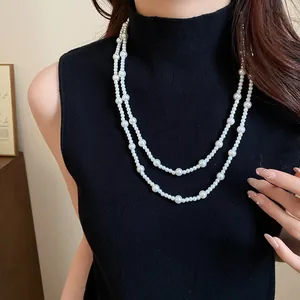 Elegant double-layer faux pearl sweater necklace on a black sleeveless turtleneck top