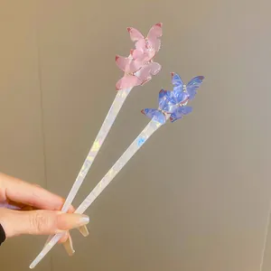 Detail view of two elegant acetate hairpins with shimmering translucent butterfly motifs.