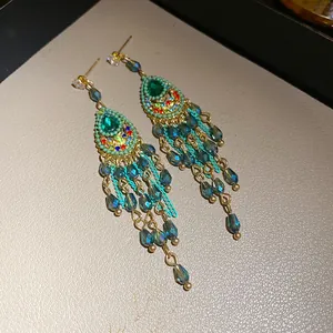 Vintage Palastohrringe mit grünen Kristallen und eleganten Tropfenquasten für Damen.