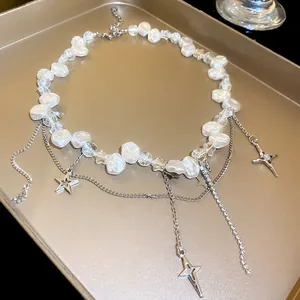 Detail view of baroque pearl necklace with rhinestone star charms on gold tray