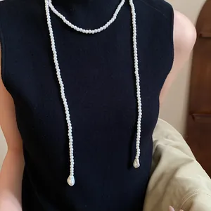 Elegant French vintage long pearl necklace worn over a black top for a chic look