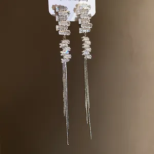 Dettaglio macro di pietre di zirconia quadrate irregolari e catene a nappe d'argento.