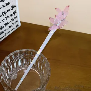 Close-up of pink acetate butterfly hair stick with iridescent finish and rhinestones.