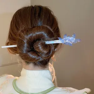 Detailed view of an elegant blue butterfly acetate hair stick styled in a hair bun.