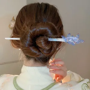 Detail view of an elegant blue butterfly acetate hair stick in a neat bun.