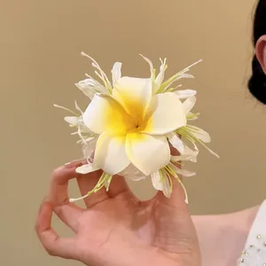 Handmade frangipani fabric flower hair clip for beach vacations, elegant white and yellow