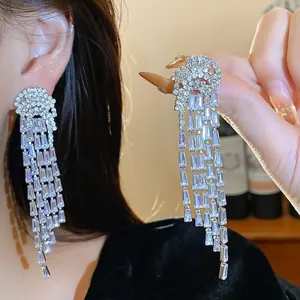 Close-up of elegant silver tassel earrings featuring sparkling baguette zircons.