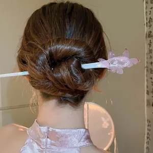 Detailed view of an elegant pink butterfly acetate hair stick styled in a classic bun
