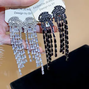 Close-up of elegant zircon tassel earrings in silver and black finishes