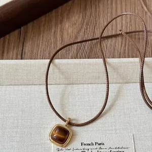Detailed view of a vintage Maillard style brown stone pendant necklace with cord