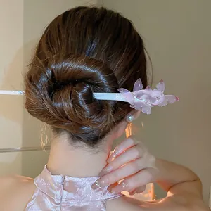 Close-up of an elegant pink butterfly acetic acid hair stick used for a bun hairstyle.