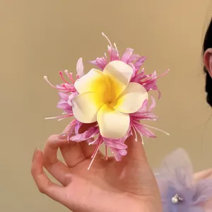 Fabric plumeria flower hair clip in pink and white for beach vacation styling