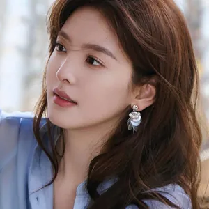 Elegant silver needle shell tassel earrings with pearls shown on a beautiful Asian model
