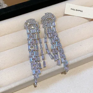 Macro view of luxury cubic zirconia tassel earrings with silver needles in a jewelry tray