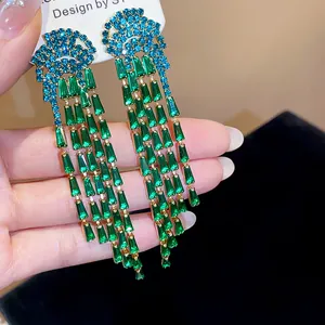 Detailed close-up of luxury emerald green and blue zircon tassel dangle earrings