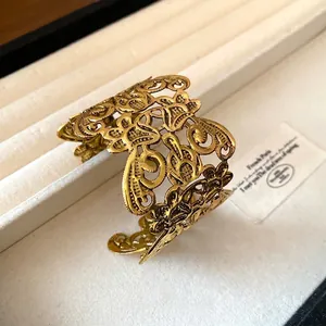 Prachtige vintage gouden opengewerkte manchetarmband met een verfijnd bloemenpatroon