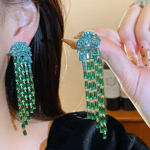 A close-up view showing the intricate details of long green zircon crystal tassel earrings