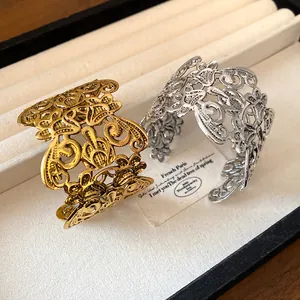 Detail van versierde holle metalen manchetarmbanden in goud en zilver