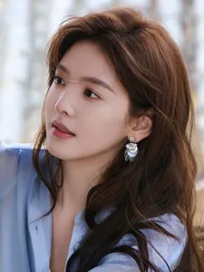 Close-up of elegant shell tassel earrings with pearls worn by an Asian model