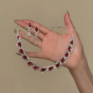 Detailed view of luxury palace style necklace and earrings set with red waterdrop rhinestones