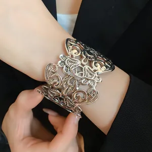 Close-up van vintage holle metalen manchetarmband met gedetailleerd bloemenpatroon