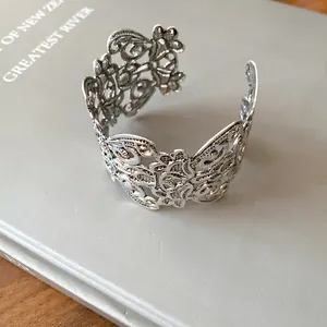 Gedetailleerd zicht op een ingewikkelde zilverkleurige bloemige opengewerkte armband
