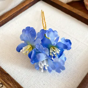 Blue fabric flower hair pin with U-shaped gold-tone clip for elegant hairstyling