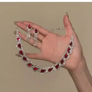 Detailed view of an elegant red teardrop rhinestone necklace and matching earrings set.