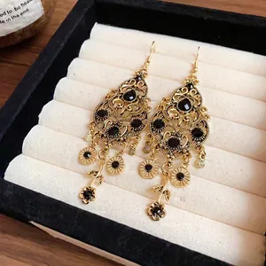 Vintage-style gold waterdrop dangle earrings with black stones and elegant tassel details