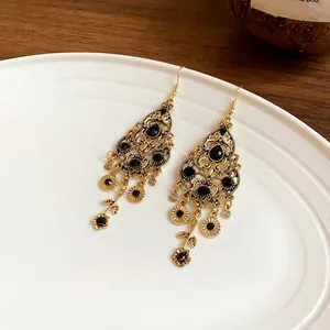 Vintage style gold drop earrings with black stones and an intricate tassel design