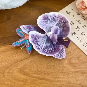 Sweet purple fabric orchid flower hair clip with a colorful starfish for seaside vacations