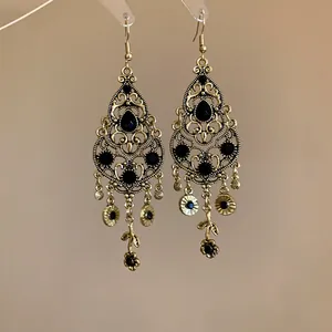Detailed view of vintage gold-tone chandelier earrings with black water drop stones