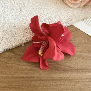 Vibrant red fabric hibiscus hair clip for seaside holiday styling