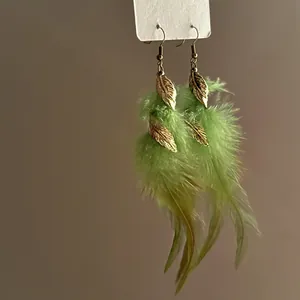 Bohemian ethnic style dangling earrings featuring green feathers and golden leaf charms