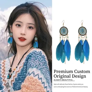 Detail shot of bohemian blue feather earrings on an Asian model and white background.