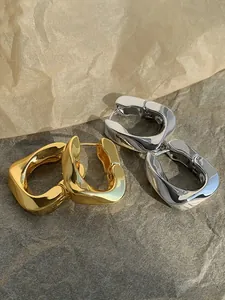Close-up of French geometric metal hoop earrings in elegant gold and silver finishes
