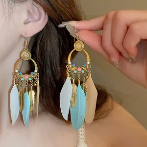 Detail view of Bohemian long feather earrings with gold leaf and colorful bead accents