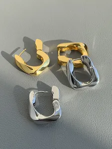 Detailed macro view of chunky geometric French style gold and silver plated earrings.