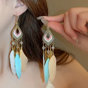 Detailed view of Bohemian feather earrings with leaf charms and colorful tassels