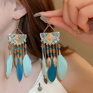 Detailed close-up of Bohemian ethnic tassel earrings featuring feathers and gold leaves