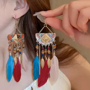 Detailed close-up of bohemian ethnic earrings featuring colorful feathers and gold tassels