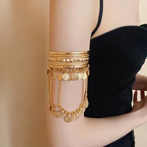 Elegant gold arm cuff featuring intricate coin tassels and a textured open band design