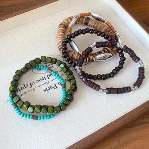 Close-up detail of bohemian wooden and coconut shell beaded bracelets with silver accents