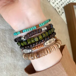 Close-up of bohemian stacked bracelets with wood beads and coconut shells on wrist