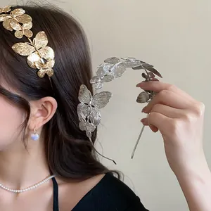 Detailed view of French vintage gold and silver metal butterfly headbands on model