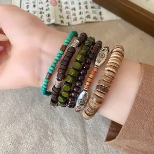 Detailed view of Bohemian layered wood bead and coconut shell bracelets on wrist