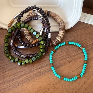 Close-up of bohemian style wood and coconut shell beaded bracelets with turquoise accents.
