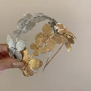 Detail view of elegant metallic butterfly headbands in vintage gold and silver.